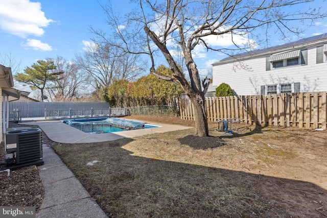 view of yard featuring central air condition unit, a fenced in pool, and a fenced backyard