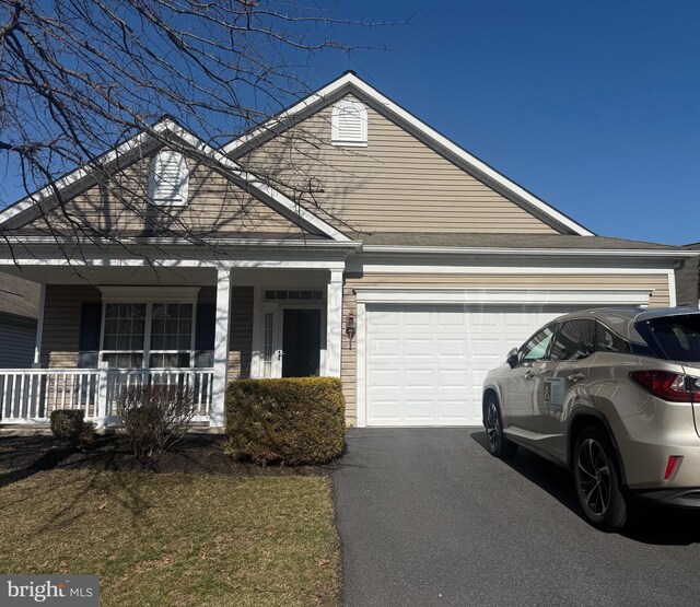 view of front of home with driveway, a porch, and a garage