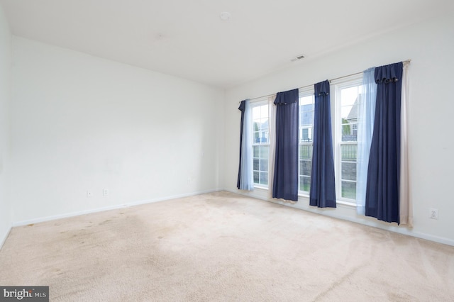 empty room with baseboards, carpet flooring, and visible vents