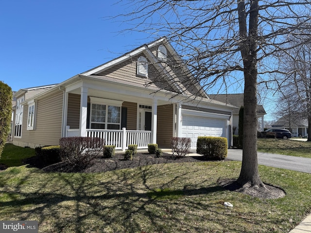 view of front facade with a porch, an attached garage, a front lawn, and driveway