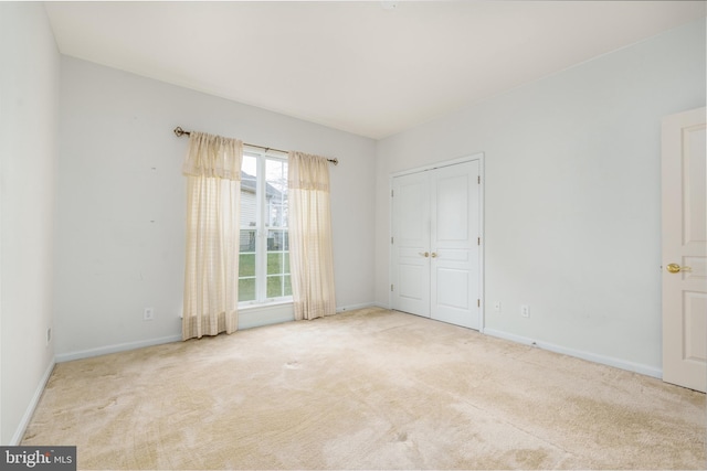 unfurnished bedroom with a closet, carpet flooring, and baseboards