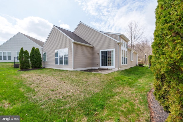 rear view of house featuring a patio area and a lawn