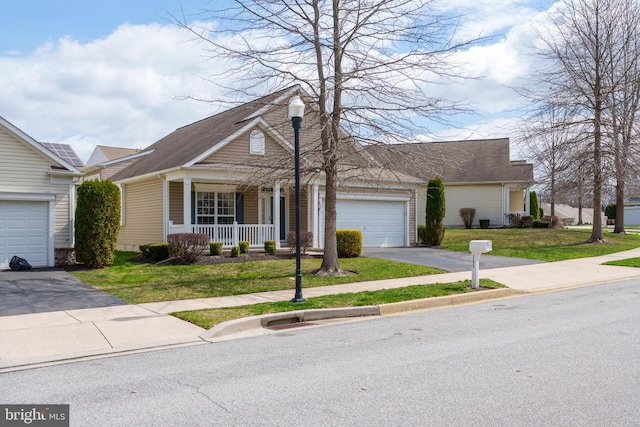 view of front of home featuring a front lawn, aphalt driveway, a garage, and covered porch