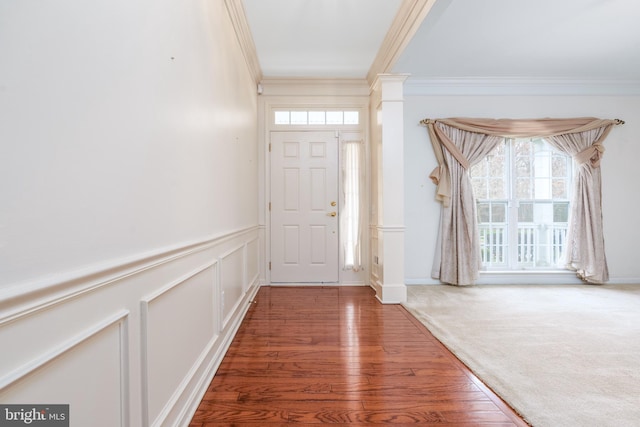 entryway with wood finished floors and ornamental molding