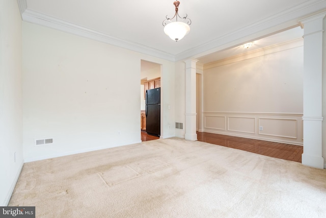 carpeted empty room featuring visible vents, ornamental molding, and ornate columns