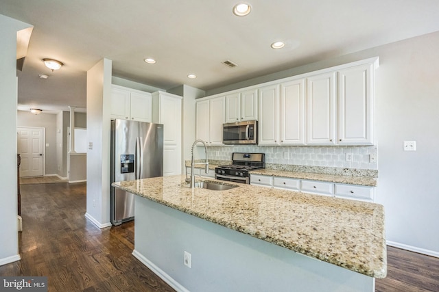 kitchen featuring dark wood-style flooring, white cabinets, tasteful backsplash, a sink, and appliances with stainless steel finishes
