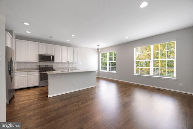 kitchen with a sink, stainless steel appliances, recessed lighting, white cabinetry, and backsplash