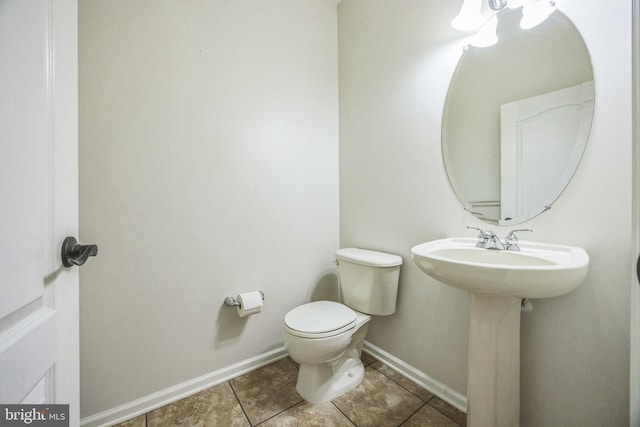 bathroom featuring tile patterned flooring, baseboards, and toilet