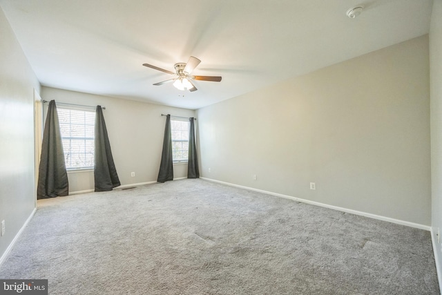 carpeted empty room featuring baseboards and ceiling fan