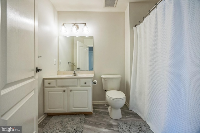 full bathroom with visible vents, vanity, wood finished floors, toilet, and baseboards