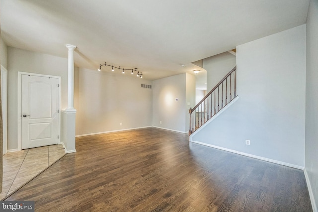 unfurnished living room featuring visible vents, wood finished floors, and stairway