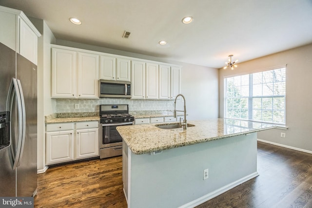 kitchen featuring decorative backsplash, visible vents, appliances with stainless steel finishes, a sink, and an inviting chandelier