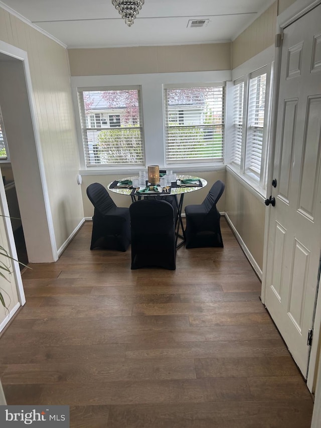 dining area featuring visible vents, ornamental molding, wood finished floors, and a healthy amount of sunlight