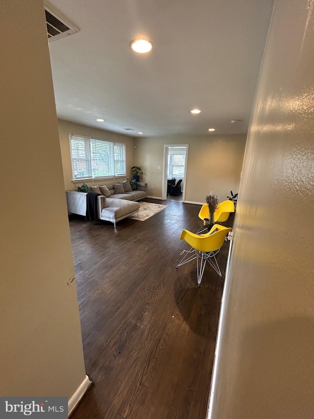 living area featuring visible vents, baseboards, recessed lighting, and wood finished floors