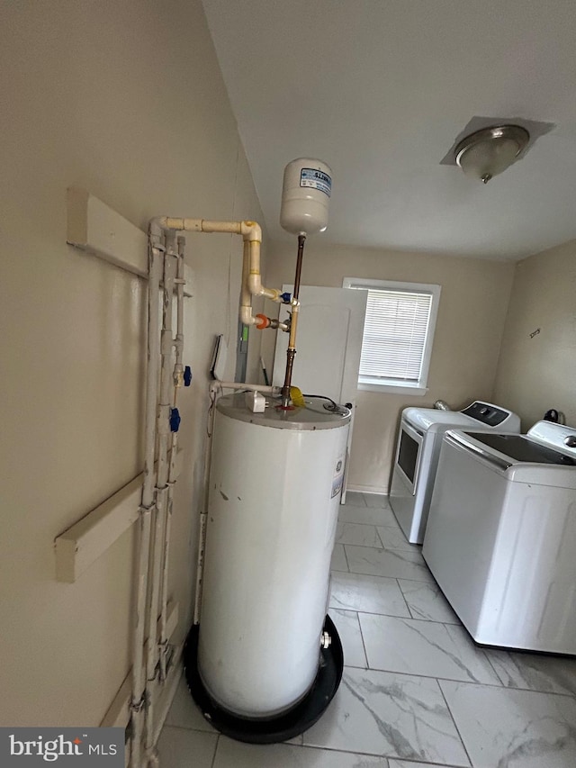 laundry room with washing machine and dryer, marble finish floor, laundry area, and gas water heater