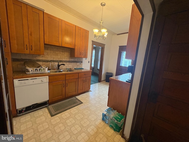 kitchen with dishwasher, light floors, brown cabinets, and a sink