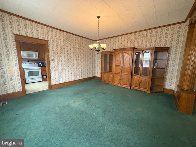 carpeted empty room featuring a chandelier, crown molding, and wallpapered walls