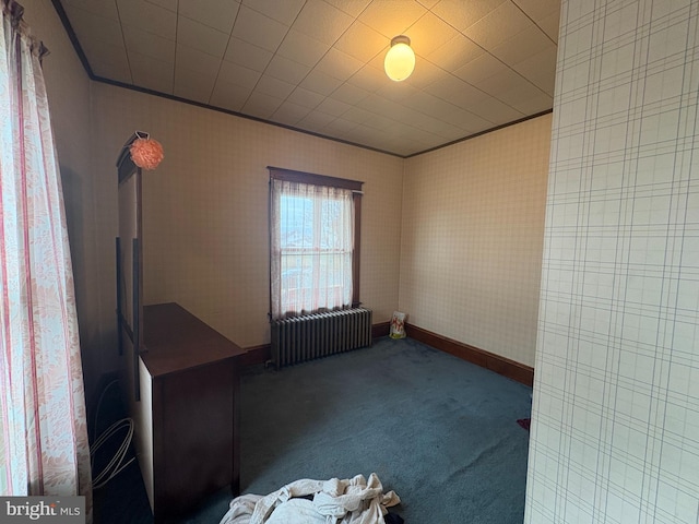 carpeted spare room with crown molding, radiator heating unit, and baseboards