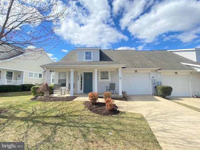view of front facade featuring a porch, an attached garage, concrete driveway, and a front yard