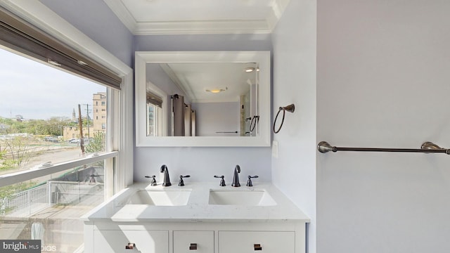 bathroom with double vanity, a sink, and ornamental molding
