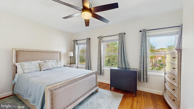 bedroom with baseboards, ceiling fan, and wood-type flooring