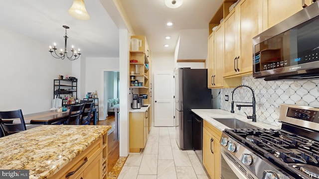 kitchen featuring decorative backsplash, marble finish floor, a chandelier, a sink, and appliances with stainless steel finishes