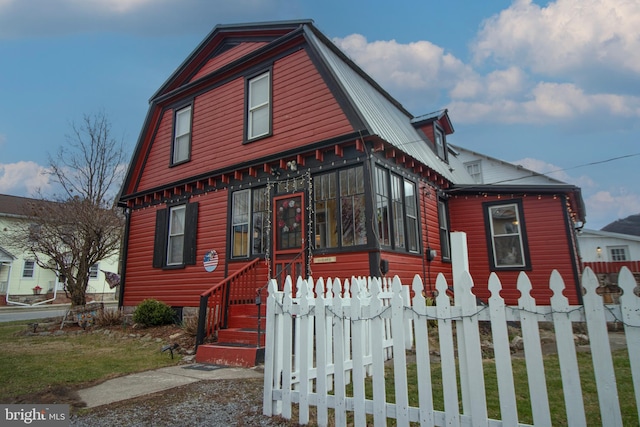 606 Ridgley St, Orbisonia, PA 17243 - view of front facade featuring a gambrel roof, a sunroom, and fence
