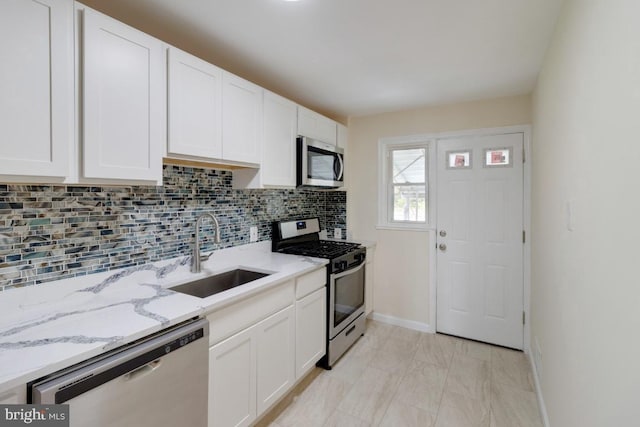 1666 Thetford Rd, Baltimore, MD 21286 - kitchen featuring stainless steel appliances, a sink, baseboards, white cabinetry, and decorative backsplash