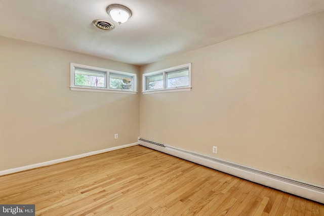 8601 Warfield Rd, Gaithersburg, MD 20882 - spare room featuring visible vents, baseboards, wood finished floors, and baseboard heating
