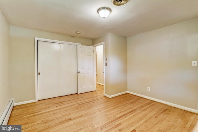 8601 Warfield Rd, Gaithersburg, MD 20882 - unfurnished bedroom featuring visible vents, a closet, wood finished floors, baseboards, and a baseboard radiator