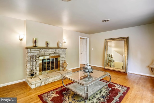 8601 Warfield Rd, Gaithersburg, MD 20882 - living area featuring baseboards, visible vents, wood finished floors, and a fireplace