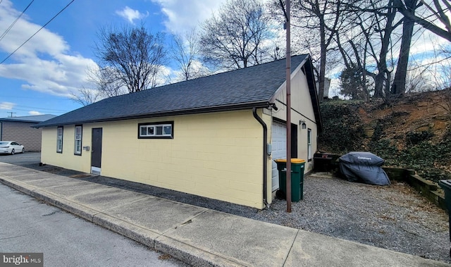 27 W Sixth St, Waynesboro, PA 17268 - view of home's exterior featuring roof with shingles, concrete block siding, and an outdoor structure