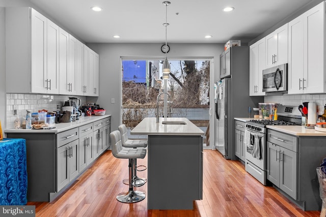 2714 W Jefferson St, Philadelphia, PA 19121 - kitchen with a center island with sink, gray cabinets, light wood-style flooring, stainless steel appliances, and a sink