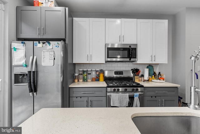 2714 W Jefferson St, Philadelphia, PA 19121 - kitchen with decorative backsplash, appliances with stainless steel finishes, gray cabinets, and white cabinetry