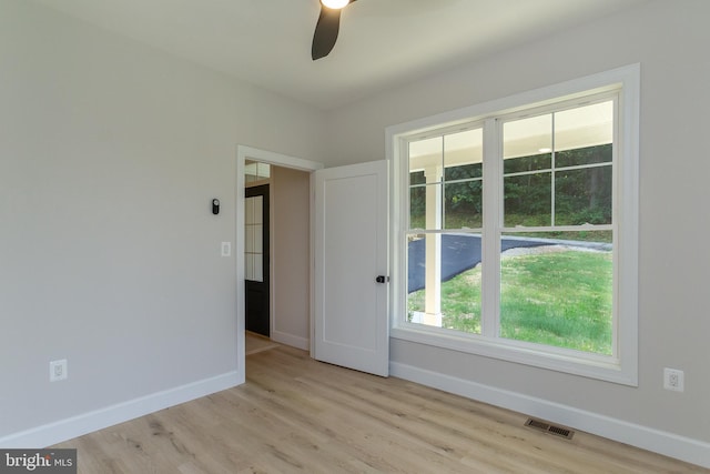 unfurnished room with light wood-type flooring, visible vents, baseboards, and a ceiling fan