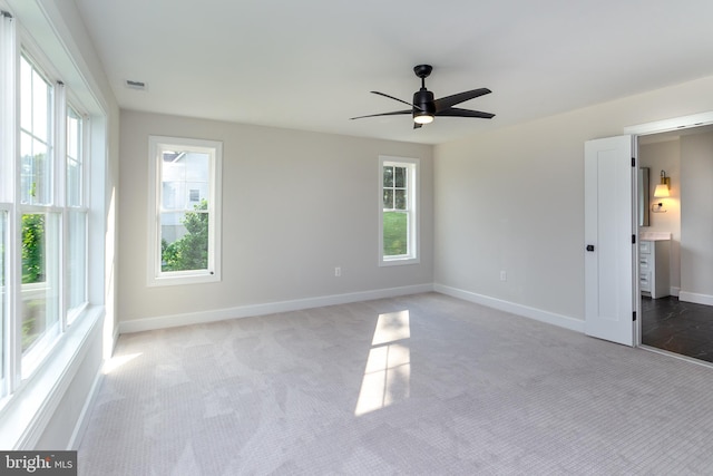 unfurnished bedroom with multiple windows, visible vents, baseboards, and carpet floors