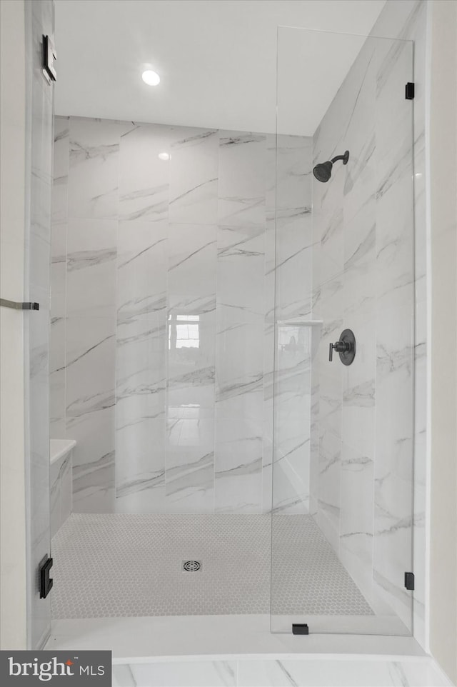 bathroom featuring a marble finish shower