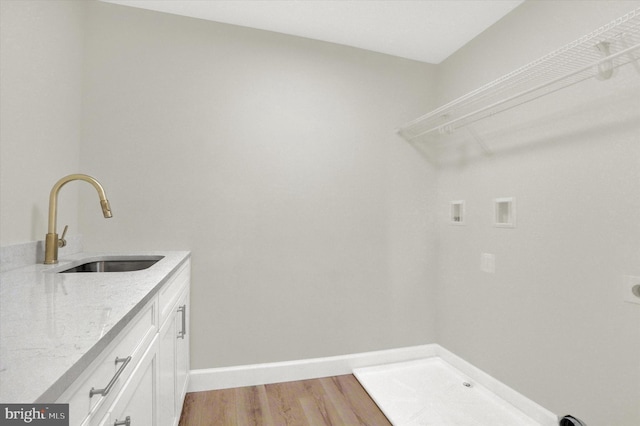 laundry area featuring baseboards, hookup for an electric dryer, light wood finished floors, a sink, and washer hookup