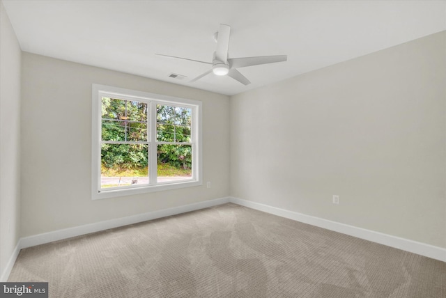 carpeted empty room featuring visible vents, ceiling fan, and baseboards