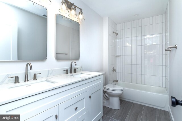 bathroom featuring a sink, toilet, bathtub / shower combination, and double vanity