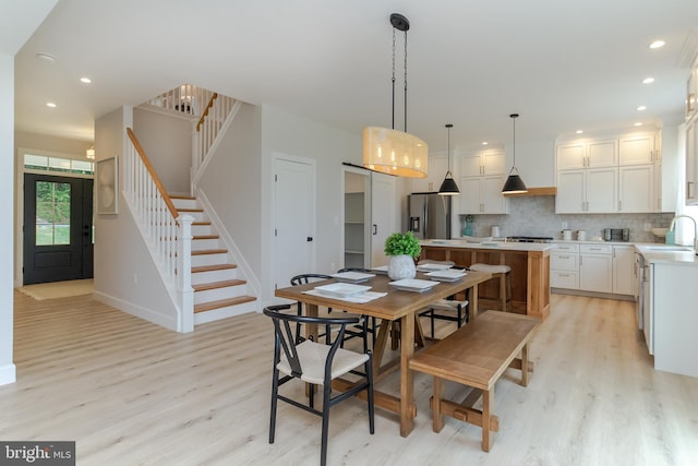 dining space with stairs, recessed lighting, and light wood finished floors