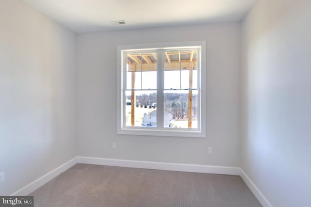 carpeted empty room with visible vents and baseboards