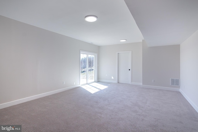 carpeted spare room with visible vents and baseboards