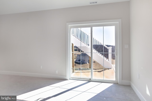 carpeted empty room featuring visible vents and baseboards