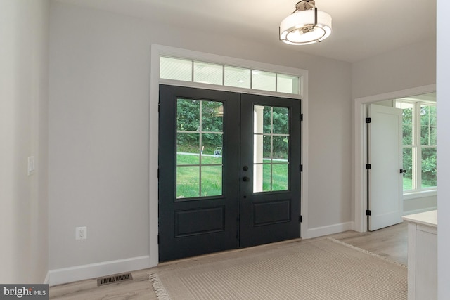 entryway with visible vents, french doors, and light wood-type flooring