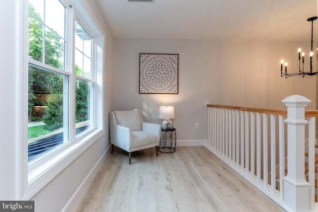 sitting room featuring visible vents, baseboards, an inviting chandelier, and wood finished floors