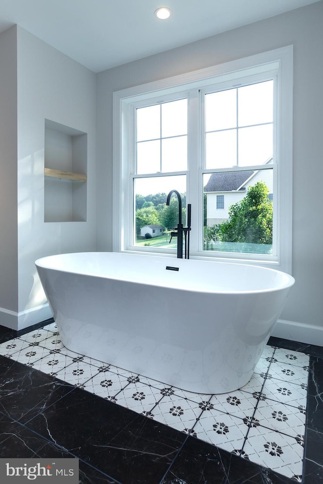 full bath with recessed lighting, baseboards, and a freestanding bath