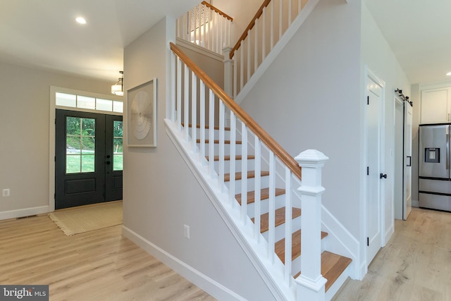 entrance foyer with stairway, baseboards, recessed lighting, a barn door, and light wood-type flooring