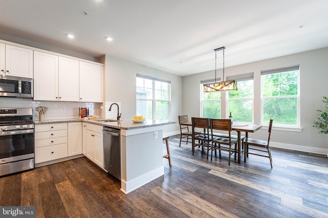 427 Whispering Elm Ln, Millersville, MD 21108 - kitchen with appliances with stainless steel finishes, a sink, a peninsula, dark wood finished floors, and baseboards