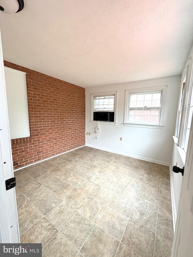 205 Parkway St, Winchester, VA 22601 - spare room featuring brick wall, a textured ceiling, and baseboards